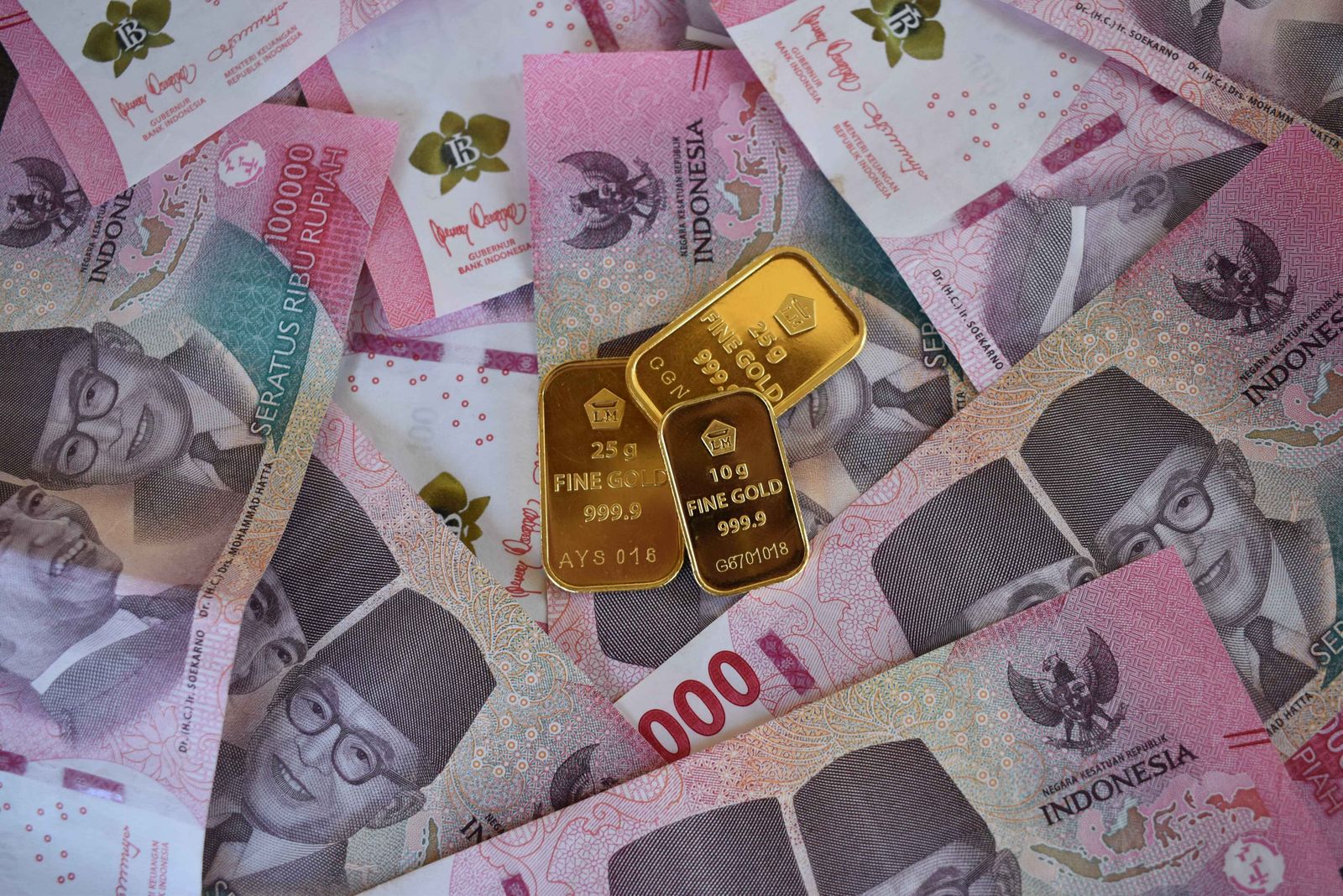Uang kertas Rupiah Indonesia berjajar bersama batangan emas, menggambarkan pembahasan OJK soal underlying asset dan stablecoin berbasis rupiah pada Oktober 2026