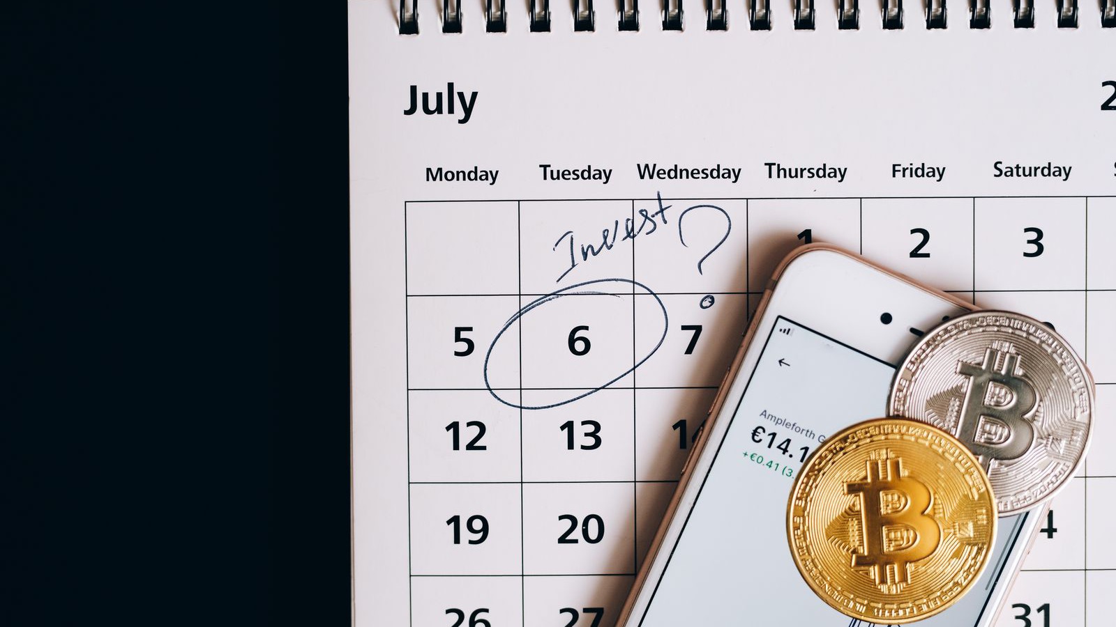 Koin bitcoin dan ponsel di atas kalender yang menandai tanggal investasi, menggambarkan ramalan Peter Brandt bahwa 4 Oktober 2026 jadi dasar siklus Bitcoin