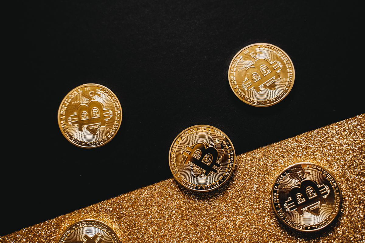 Koin emas dan Bitcoin berkilau di atas latar hitam, menggambarkan nisab zakat kripto setara 85 gram emas